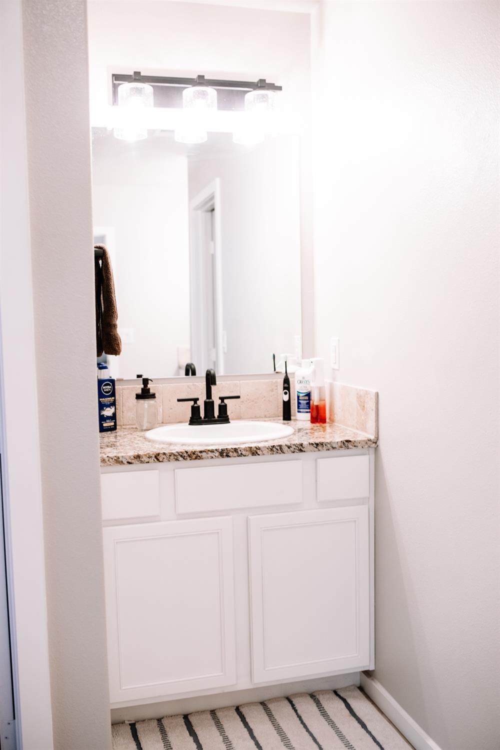 3224 Virginia Avenue Lubbock, TX 79407 - Photo 26 of 39 a bathroom with a sink and a mirror