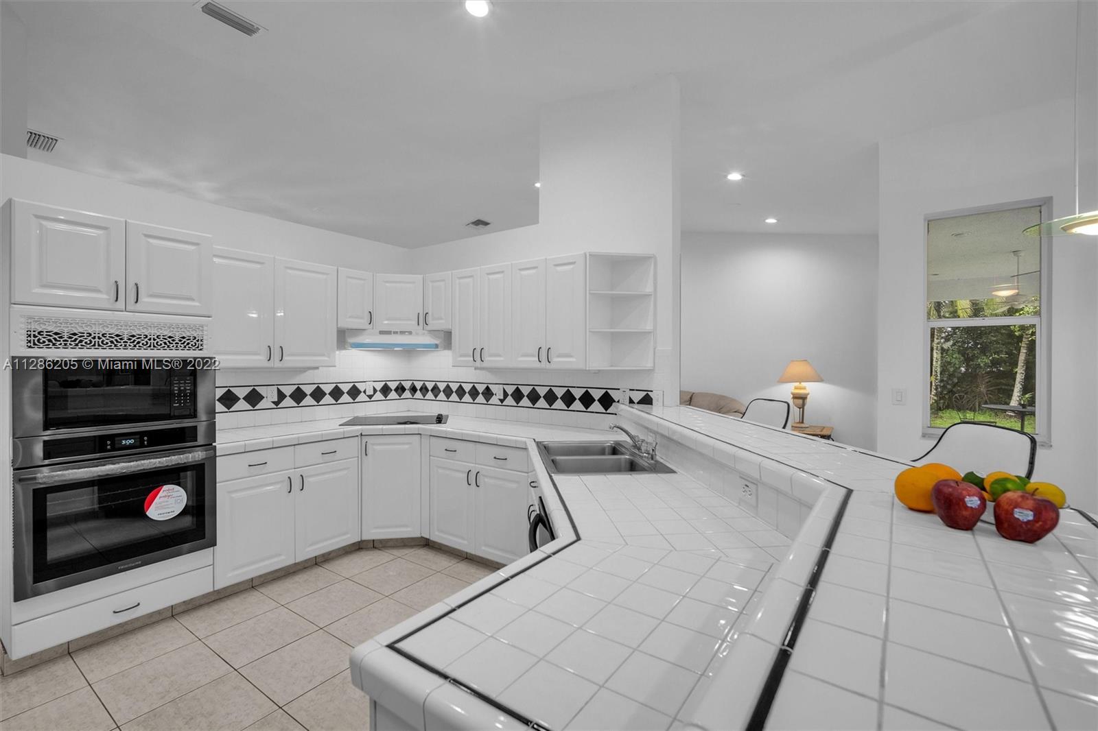 17880 Southwest 66th Street Southwest Ranches, FL 33331 - Photo 15 of 57 a kitchen that has a sink and a stove in it