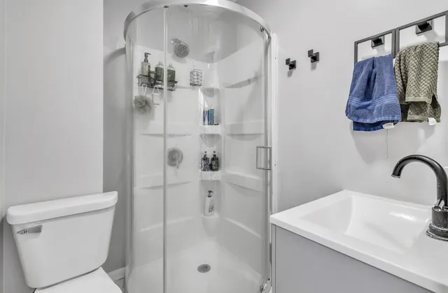 a bathroom with a sink a toilet and shower