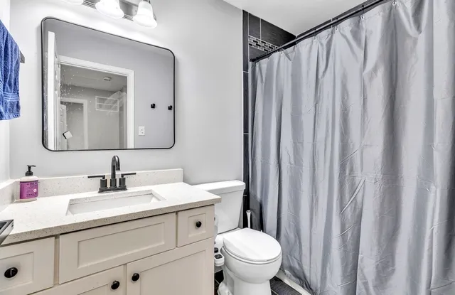 a bathroom with a toilet a sink and a mirror