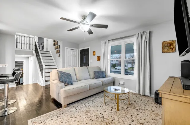 a living room with furniture a flat screen tv and a large window