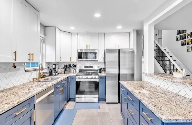 a kitchen with stainless steel appliances granite countertop a sink stove and refrigerator