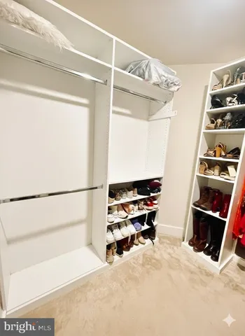 a view of walk in closet with clothes and shoes