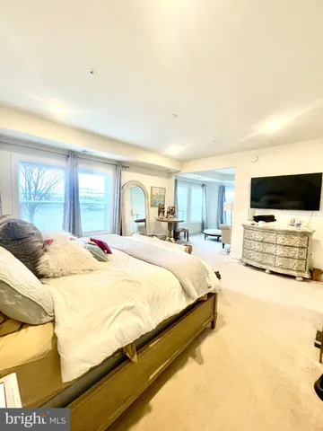 a spacious bedroom with a bed and a television