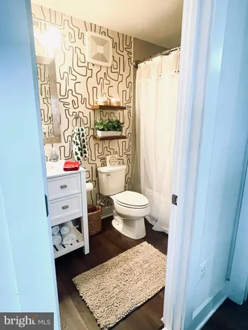 a room with wooden floor and potted plant