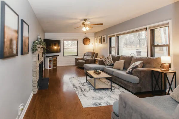 a living room with furniture a fireplace and a flat screen tv