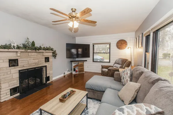 a living room with furniture a fireplace and a large window