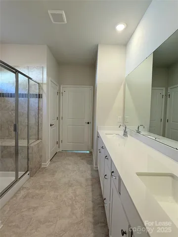 a spacious bathroom with a double vanity sink and mirror