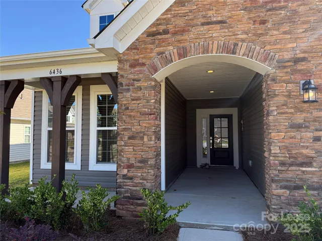 a front view of a house with potted plants