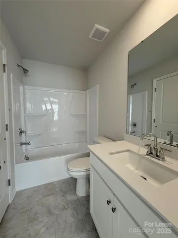 a bathroom with a granite countertop sink a toilet and bathtub