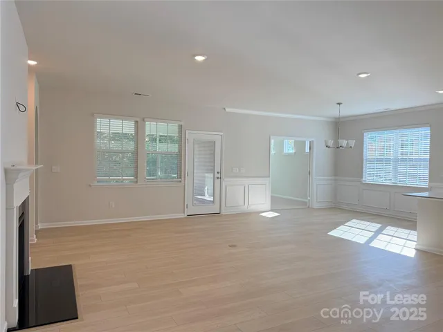 a view of an empty room with a fireplace and a window