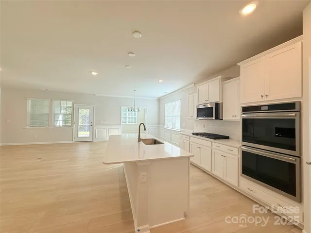 a kitchen with stainless steel appliances granite countertop a sink and a stove