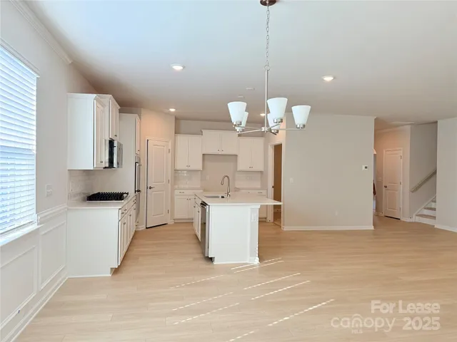 a view of a kitchen with a sink and chandelier