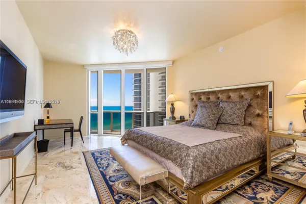 a bedroom with a bed table and chair