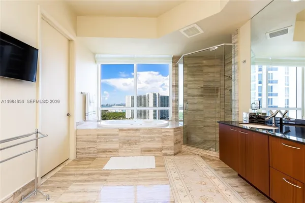 a large bathroom with a granite countertop sink a large mirror and shower