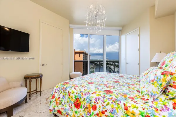 a bedroom with a bed and a chandelier
