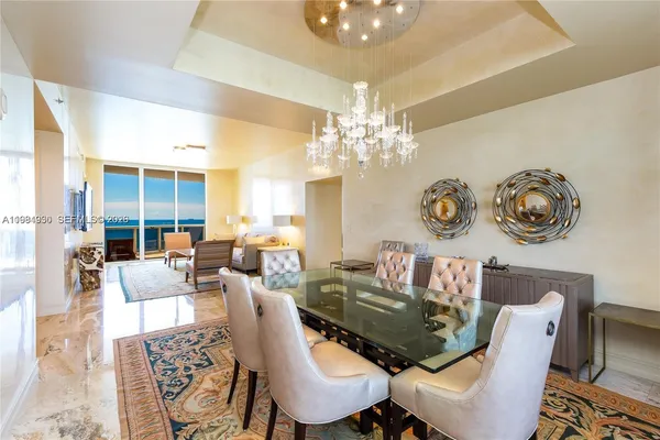 a dining room with furniture a rug and a chandelier