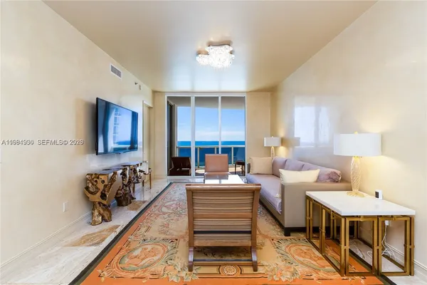 a living room with furniture and a chandelier