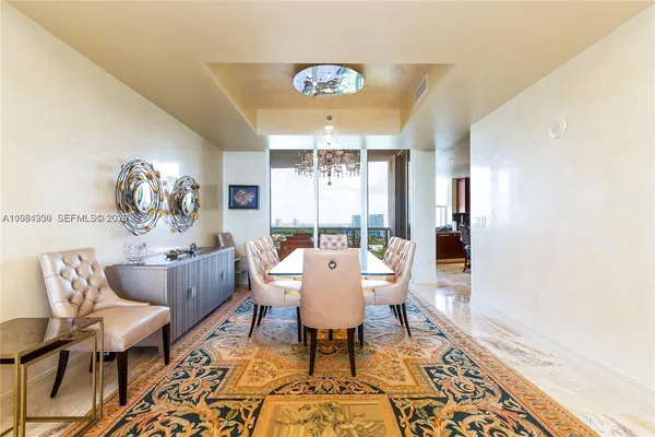 a dining room with wooden floor and a chandelier