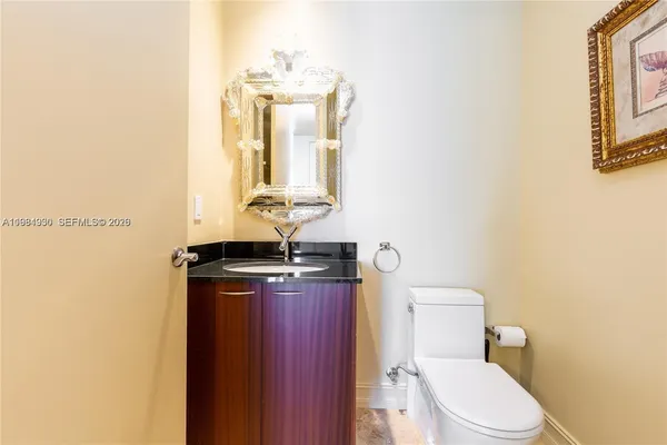 a bathroom with a granite countertop toilet sink and mirror