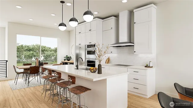 a kitchen with stainless steel appliances kitchen island granite countertop a table chairs in it and wooden floors