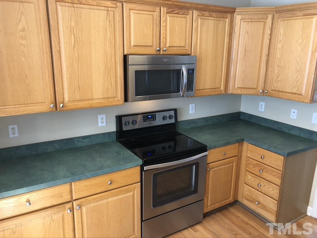 200 Oak Pine Drive Apex, NC 27502 - Photo 12 of 26 a kitchen with granite countertop white cabinets and stainless steel appliances