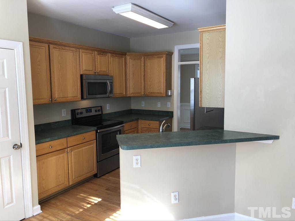 200 Oak Pine Drive Apex, NC 27502 - Photo 13 of 26 a kitchen with kitchen island a sink stainless steel appliances and cabinets