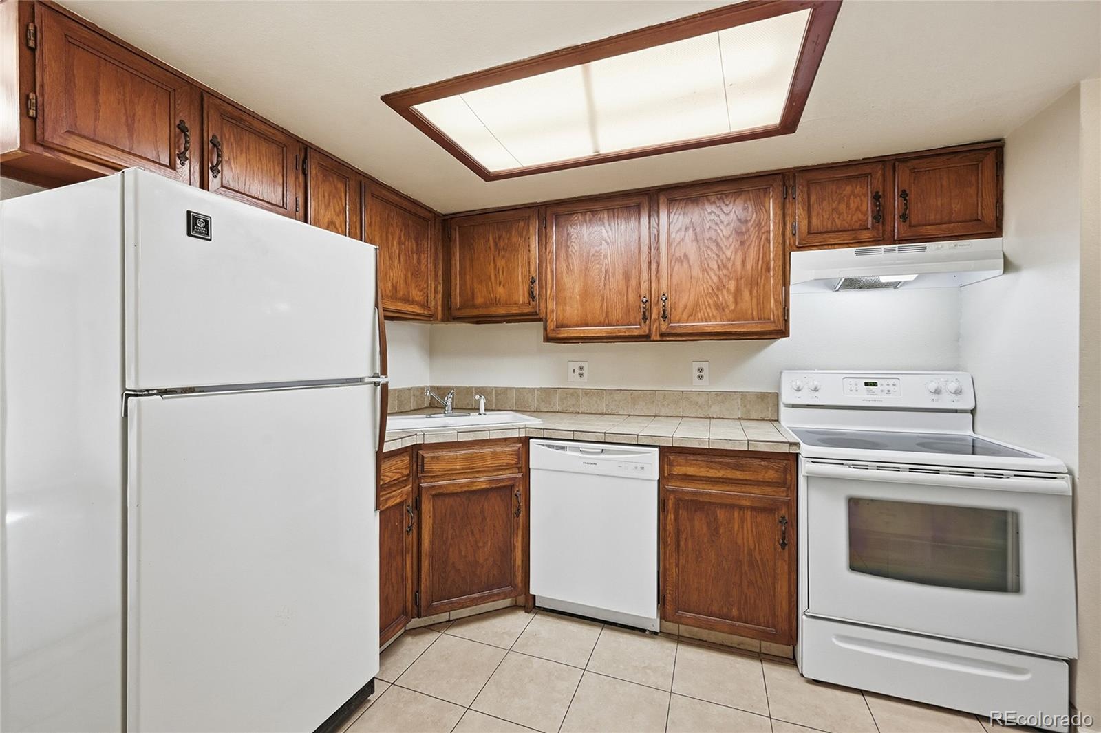 1885 South Quebec Way, Unit A18 Denver, CO 80231 - Photo 11 of 31 a kitchen with a stove top oven sink and refrigerator