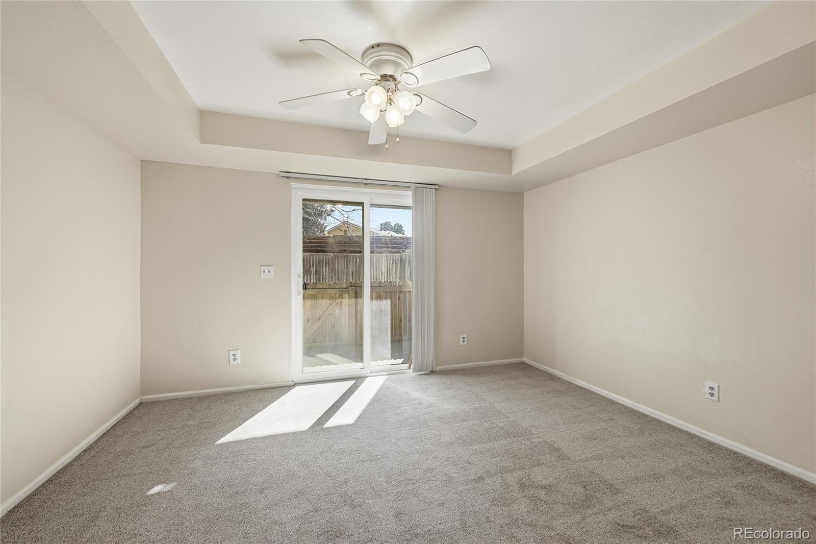 1885 South Quebec Way, Unit A18 Denver, CO 80231 - Photo 13 of 31 an empty room with chandelier fan and windows