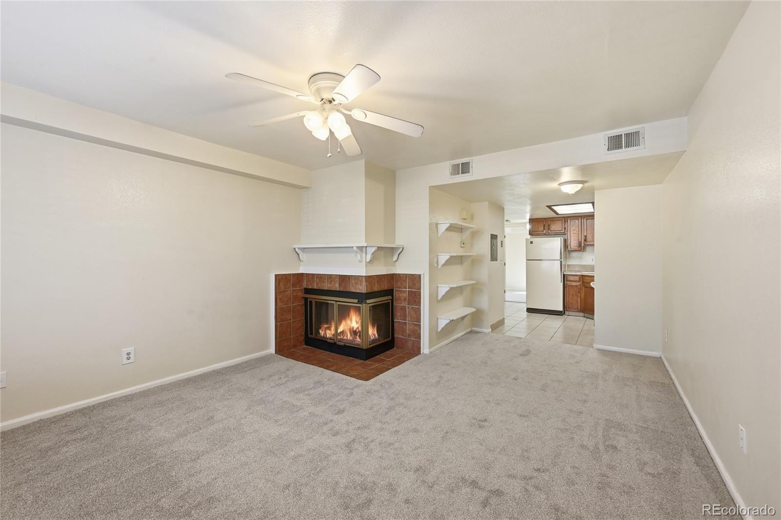 1885 South Quebec Way, Unit A18 Denver, CO 80231 - Photo 6 of 31 an empty room with a fireplace and fan
