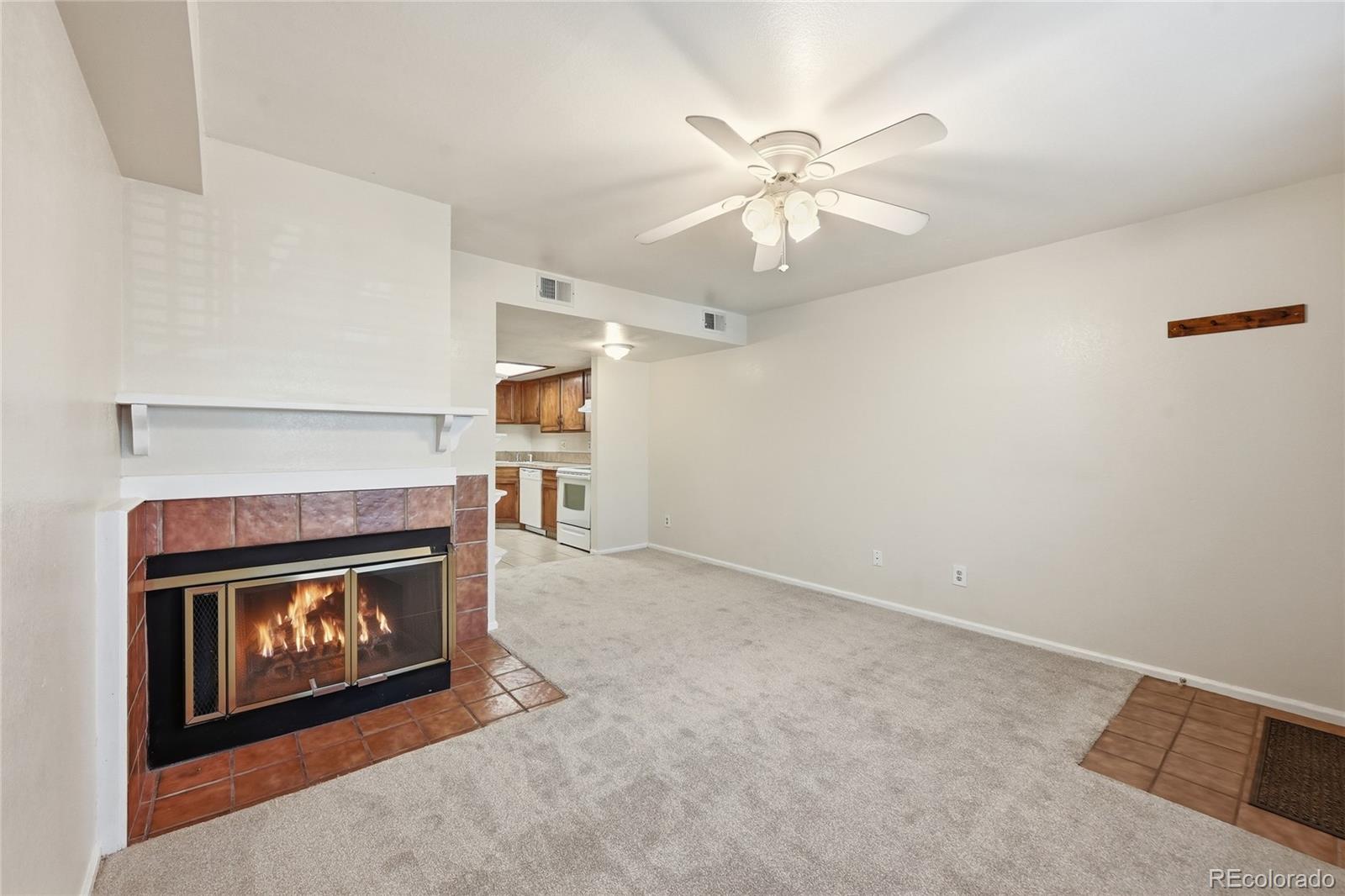 1885 South Quebec Way, Unit A18 Denver, CO 80231 - Photo 8 of 31 an empty room with fireplace and fan
