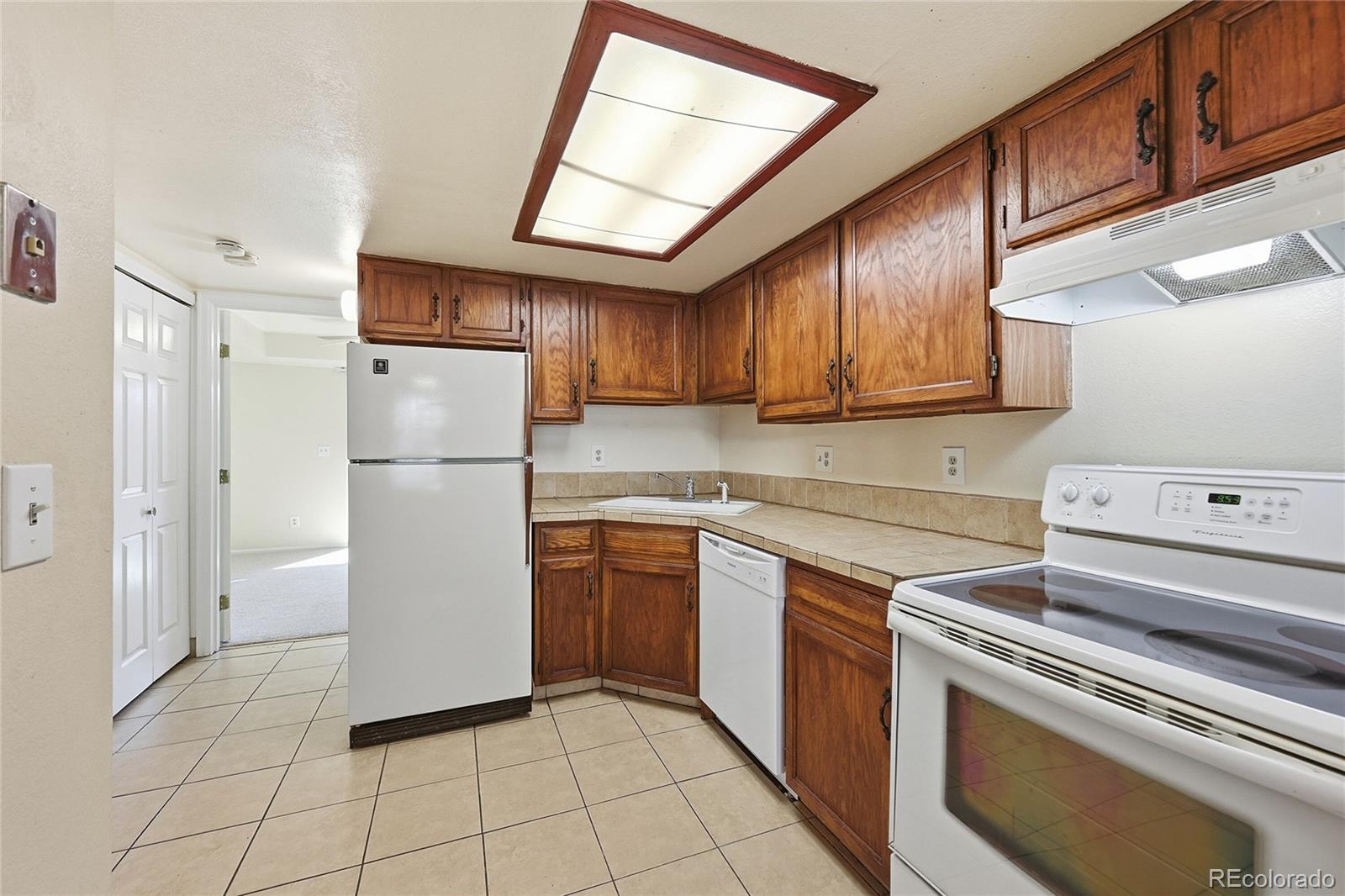 1885 South Quebec Way, Unit A18 Denver, CO 80231 - Photo 10 of 31 a kitchen with a refrigerator sink and cabinets