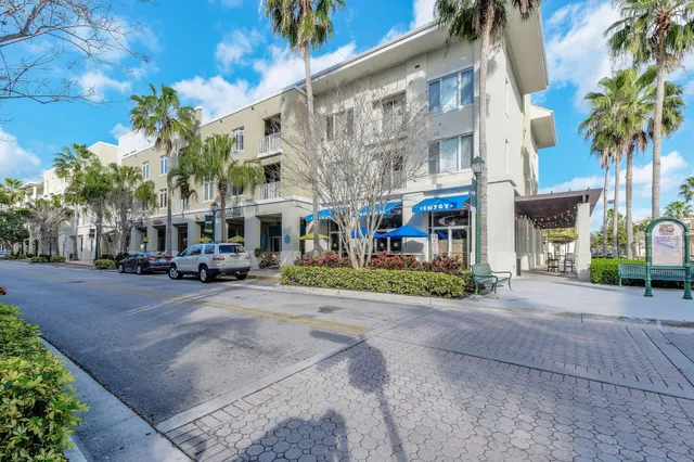 a view of a white house with a big yard and large trees