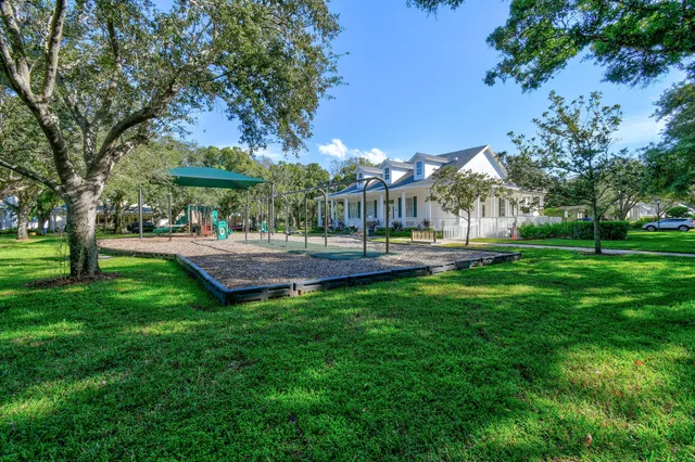 a view of house with a big yard and potted plants