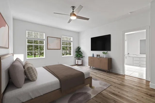 a bedroom with a bed window tv and wooden floor
