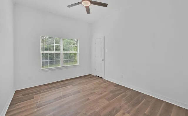 wooden floor in an empty room with a window