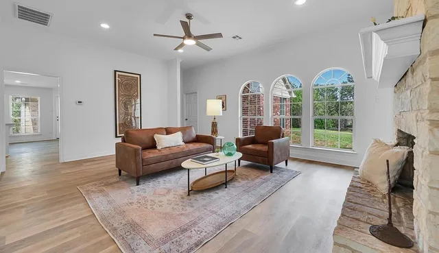 a living room with furniture fireplace and a large window