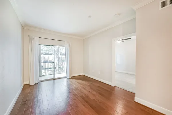 a view of a big room with wooden floor and a window