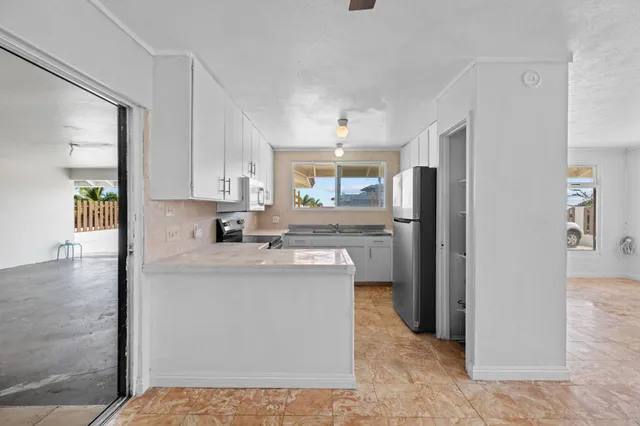 a kitchen with granite countertop white cabinets and a stove