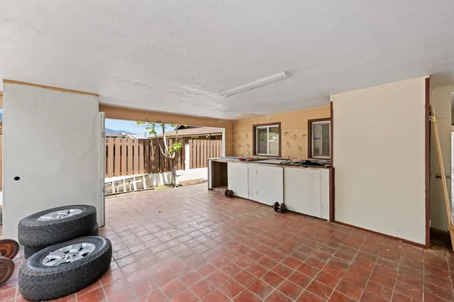 a kitchen with granite countertop a refrigerator a stove a sink dishwasher and white cabinets with wooden floor