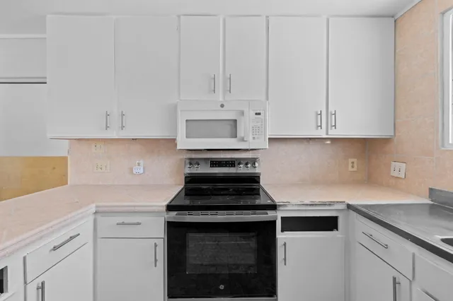 a kitchen with white cabinets and a sink