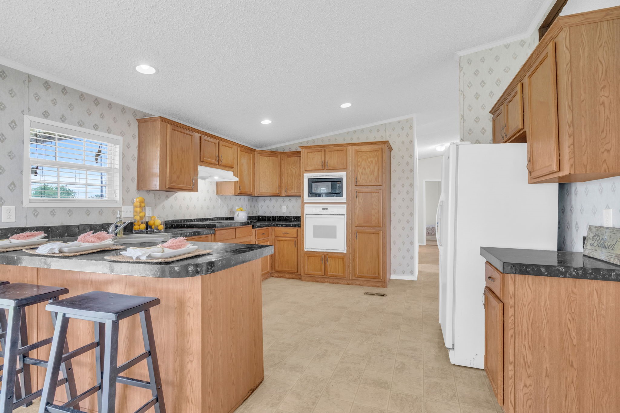 37038 Bell Road Waller, TX 77484 - Photo 14 of 43 a kitchen with stainless steel appliances granite countertop a stove a refrigerator a oven a sink a dining table and chairs with wooden floor