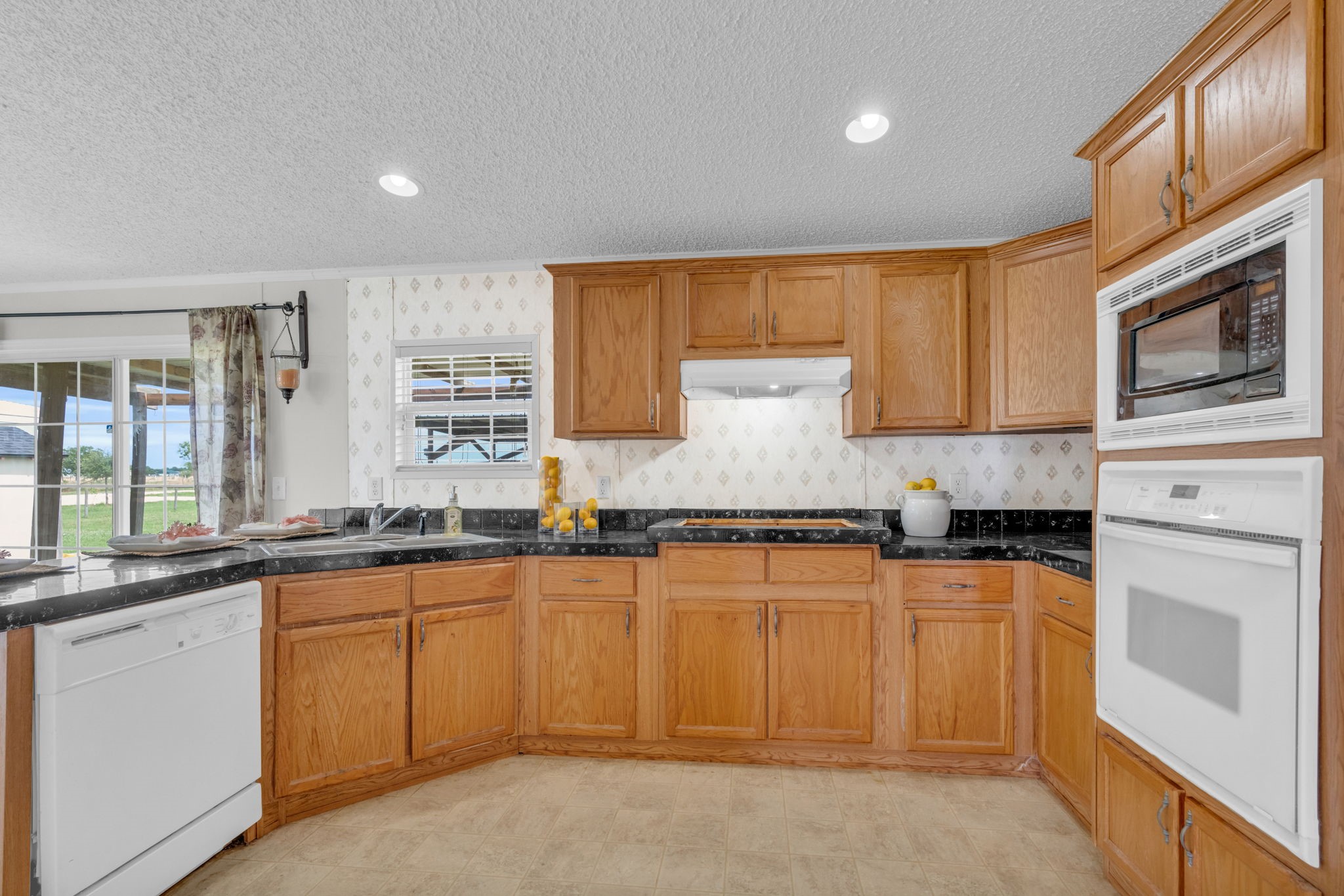 37038 Bell Road Waller, TX 77484 - Photo 16 of 43 a kitchen with granite countertop white cabinets sink and stainless steel appliances