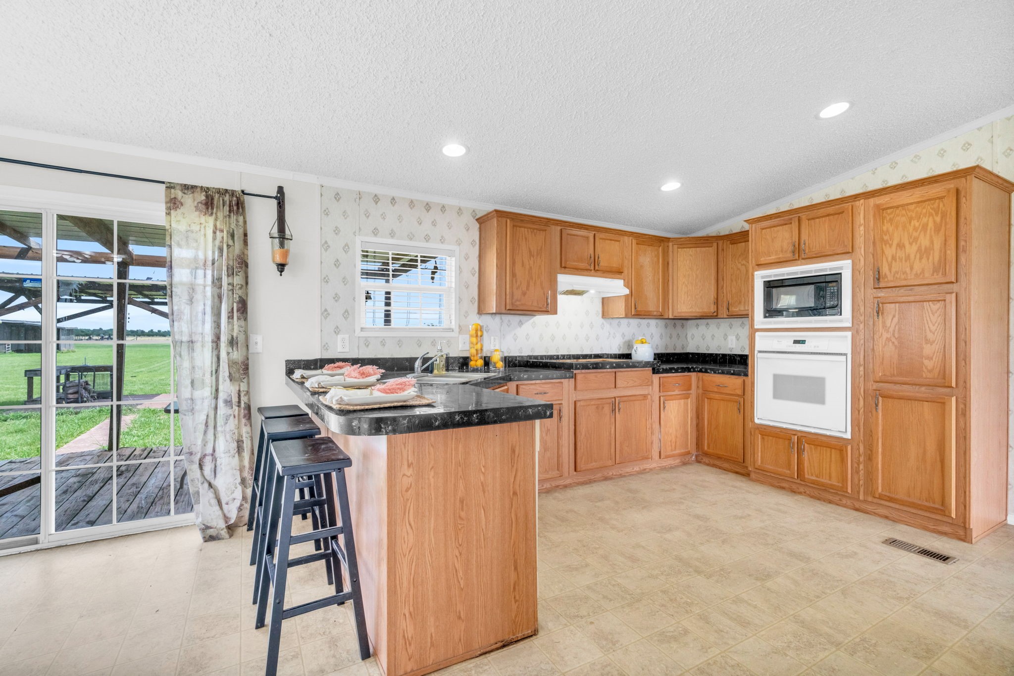 37038 Bell Road Waller, TX 77484 - Photo 18 of 43 a kitchen with granite countertop a stove a sink a refrigerator and white cabinets with wooden floor