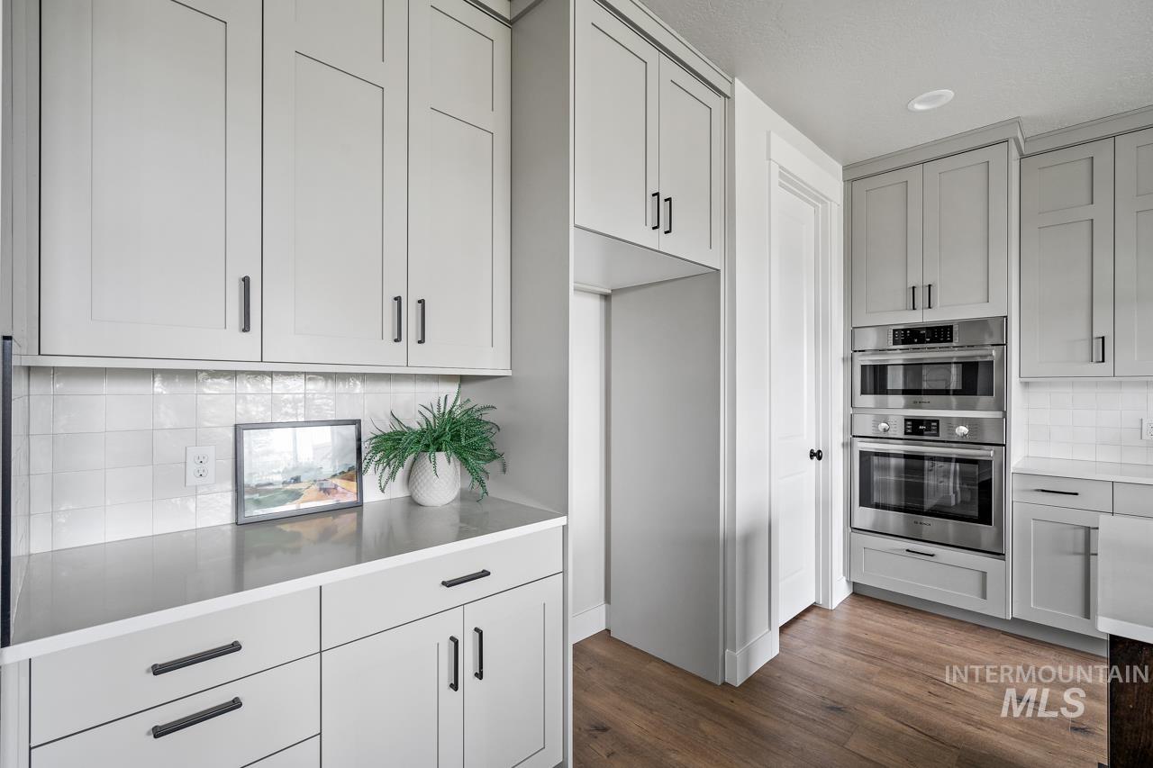 1101 East Crescendo Street Meridian, ID 83642 - Photo 11 of 31 Kitchen featuring tasteful backsplash, dark wood finished floors, and double oven
