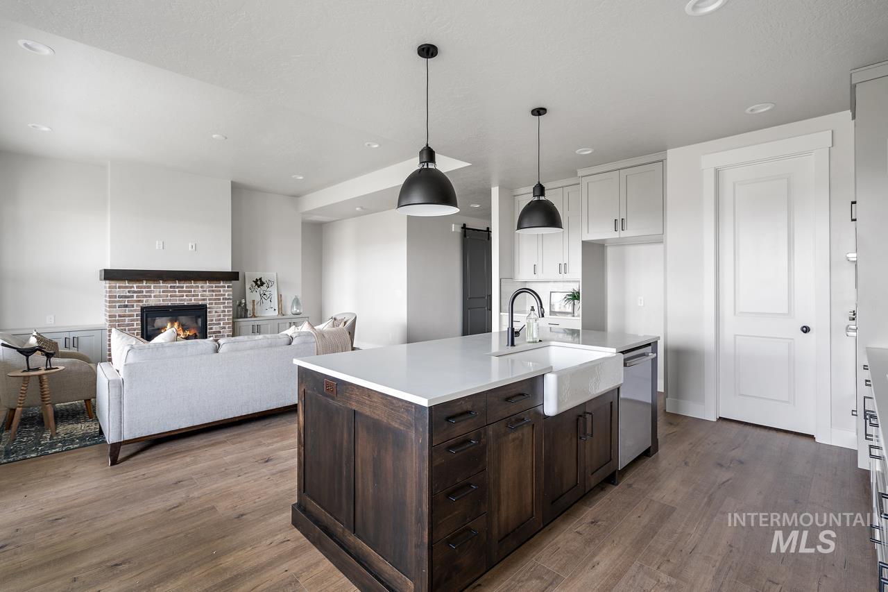 1101 East Crescendo Street Meridian, ID 83642 - Photo 20 of 31 Kitchen with dark brown cabinetry, dark wood-style flooring, hanging light fixtures, a kitchen island with sink, and recessed lighting