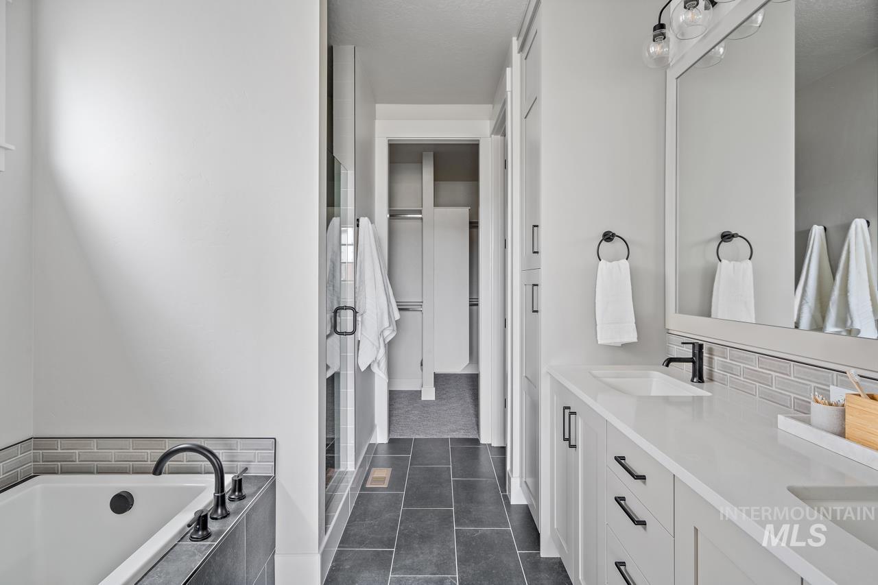 1101 East Crescendo Street Meridian, ID 83642 - Photo 29 of 31 Full bath featuring double vanity, dark tile patterned flooring, a bath, and a shower stall