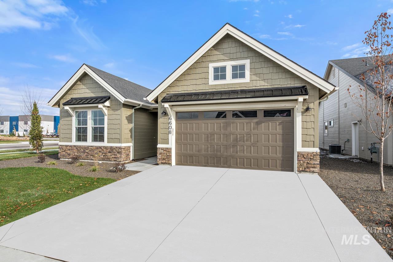 1101 East Crescendo Street Meridian, ID 83642 - Photo 4 of 31 Craftsman inspired home with stone siding, concrete driveway, a garage, a standing seam roof, and a metal roof