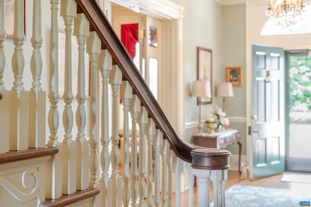 a dining room with wooden floor and stairs