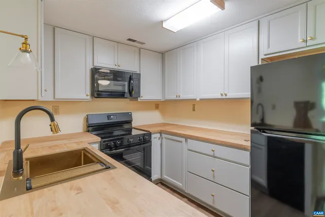 a kitchen with stainless steel appliances a stove sink and cabinets